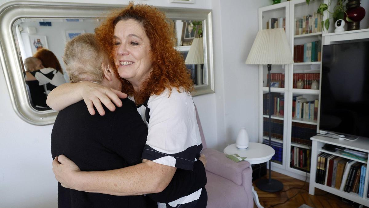 Una cuidadora abraza a su madre enferma