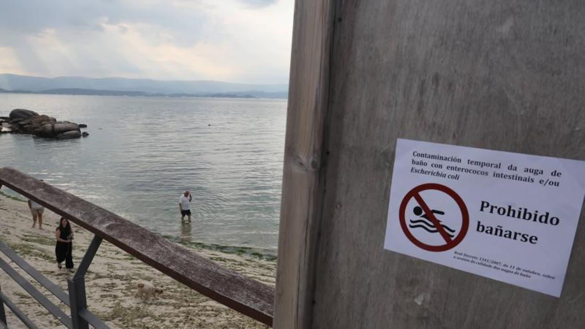 El cartel de prohibición del baño, este lunes en la playa de Canelas.