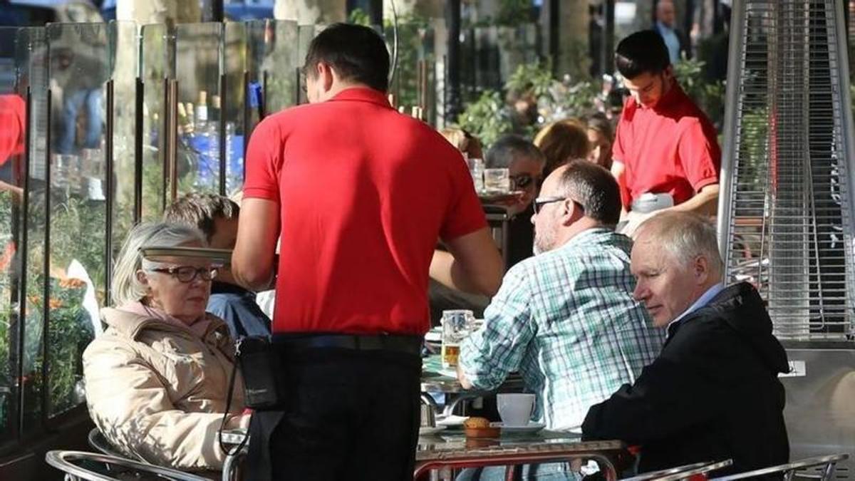 Un camarero atiende a unos clientes.