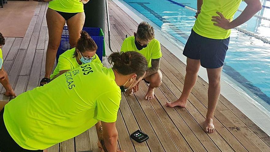 Una clase de reanimación cardiopulmonar del curso en la piscina.