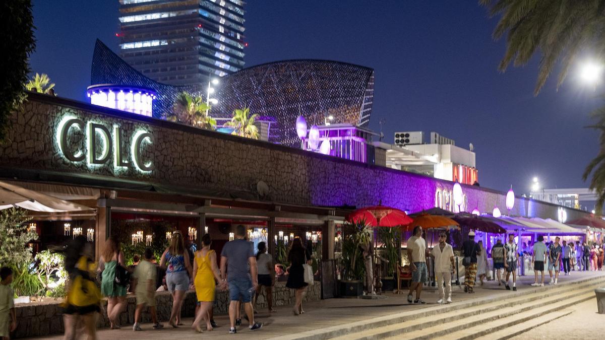 Paseantes en la zona de restaurantes y bares alrededor del hotel Arts en el paseo marítimo de Barcelona