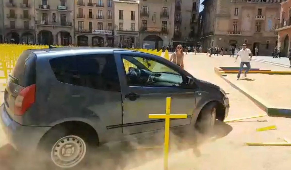 Un conductor arrolla las cruces amarillas plantadas en la plaza mayor de Vic.