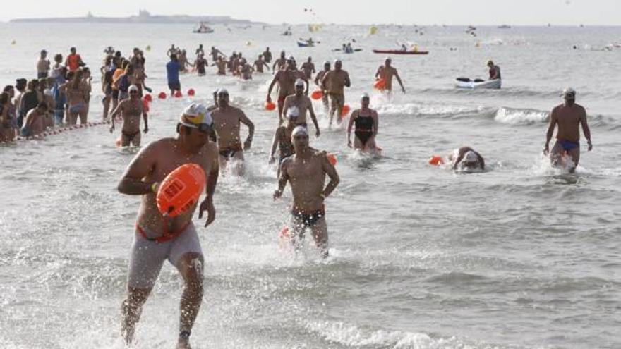 Instante de la prueba en la que los nadadores van entrando en la meta situada en la playa del Varadero.