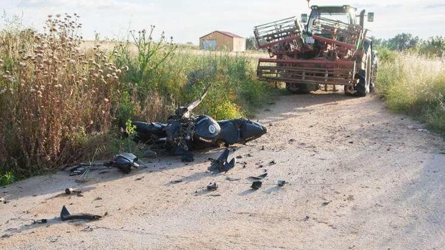 La moto del joven fallecido en el siniestro, y el tractor contra el que colisionó en las inmediaciones de El Perdigón.