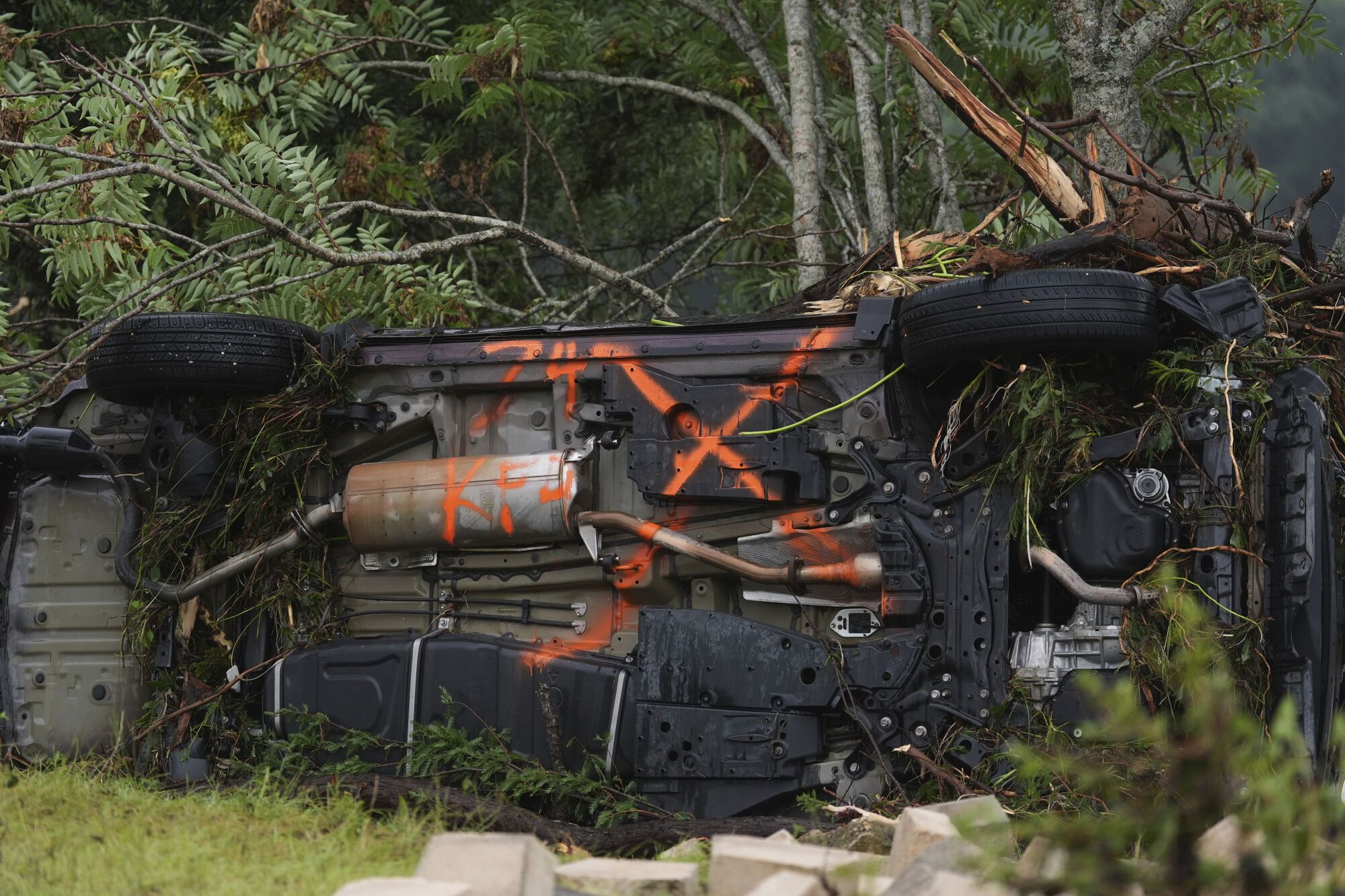 An overturned vehicle is caught in debris along the Guadalupe River after a flash flood struck the area, Friday, July 4, 2025, in Kerrville, Texas. (AP Photo/Eric Gay)