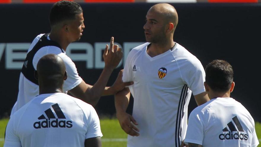 Santos conversa con Abdennour durante el entrenamiento de hoy.