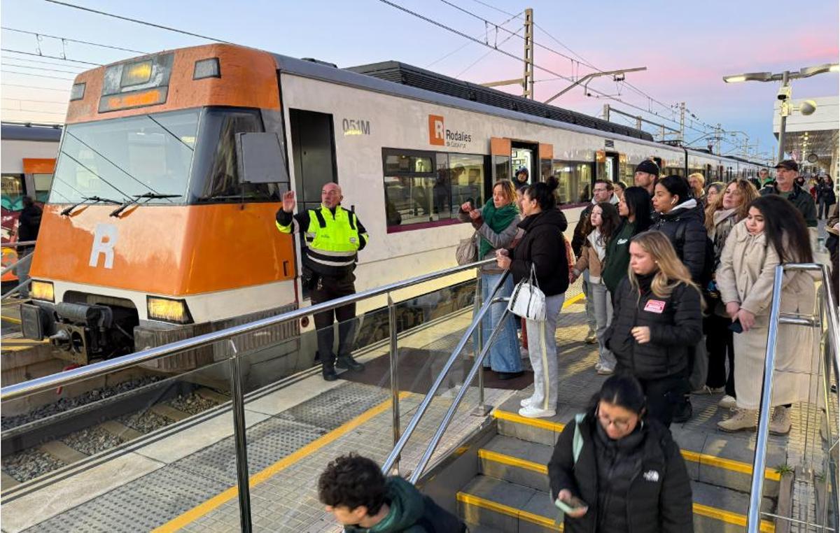 Personal de seguretat informant els viatgers a l’andana de Renfe l’estació d’Arenys de Mar
