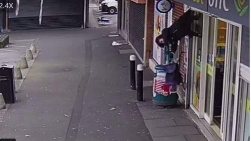 Vídeo: Se queda enganchada en la persiana de una tienda y al subirla... la mujer se queda colgando