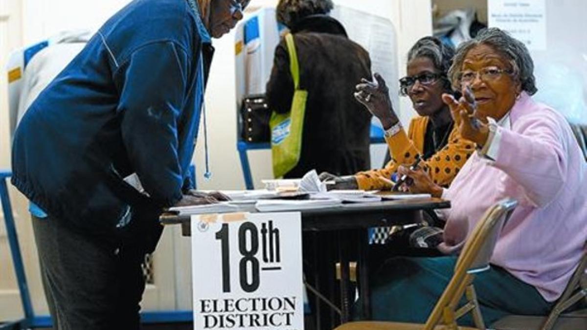 Ciudadanos de Nueva York depositan su voto en un colegio electoral situado en una escuela de Harlem, ayer.