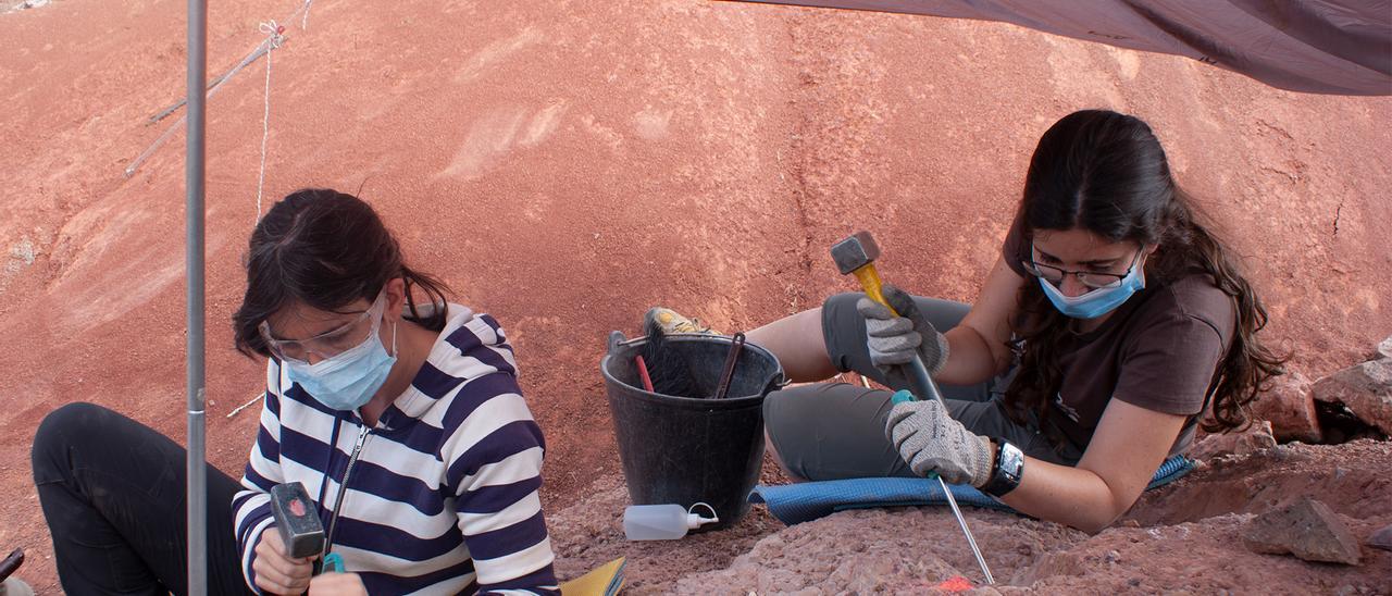 Dos jóvenes de la Universidad de Zaragoza trabajan en un yacimiento arqueológico de Aragón.