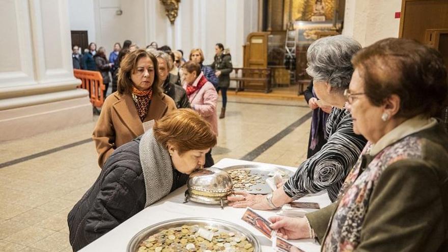 Las mujeres besan el trozo de cráneo que se encuentra en el interior del recipiente de plata.