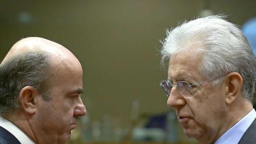 El ministro de Economía, Luis de Guindos, y el primer ministro italiano, Mario Monti, se saludan antes del inicio del Ecofin.