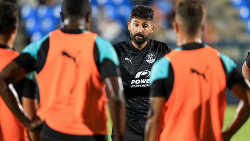 Guillermo Fernández Romo, técnico de la UD Ibiza, conversa con  algunos de sus jugadores.