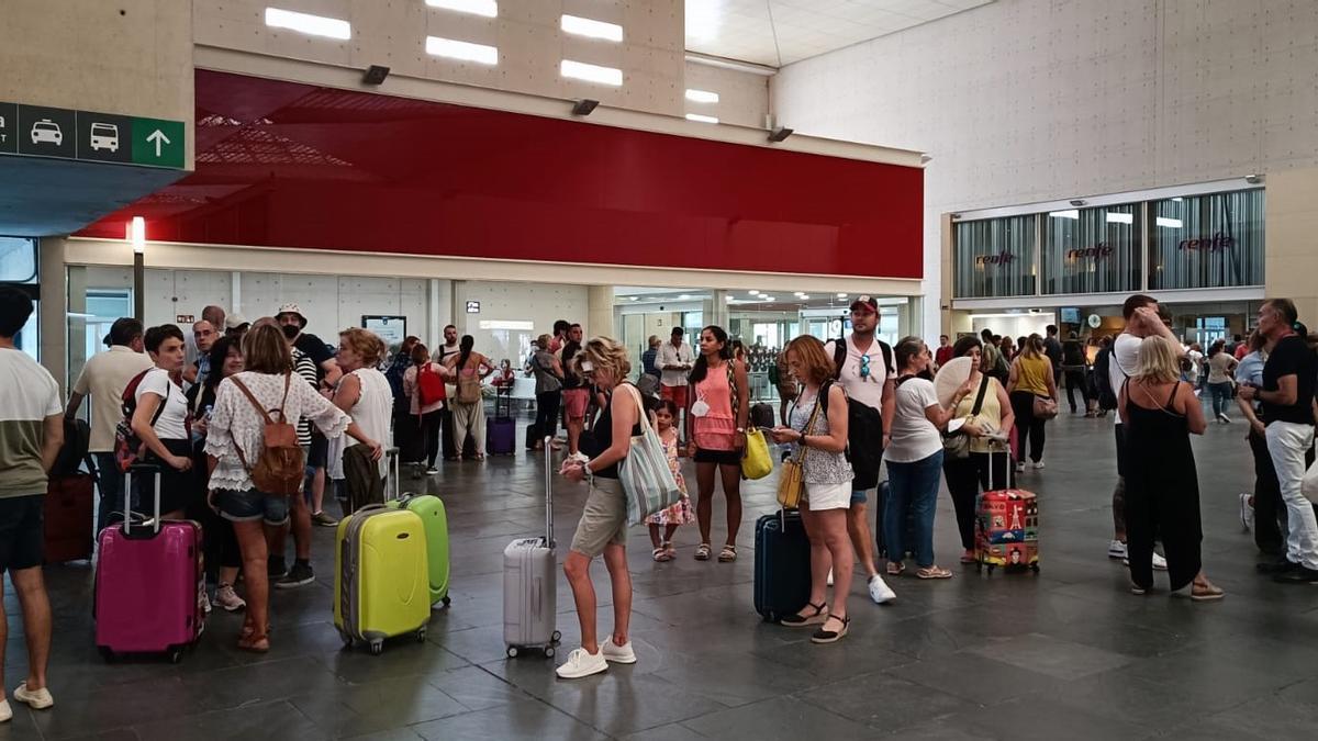 Numerosos viajeros hacen cola ante el Centro de Servicios de Renfe, esta mañana, para pedir que los reubiquen tras la supresión de varios trenes de alta velocidad.