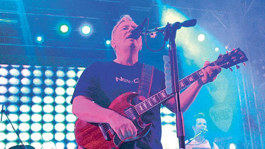 La banda británica New Order, con Bernard Sumner (con camiseta del propio grupo) en primer plano y atrás Tom Chapman (con una de Kate Moss).