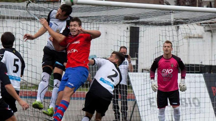 Saavedra despeja un balón de cabeza ante David, Pelayo y Bussman.