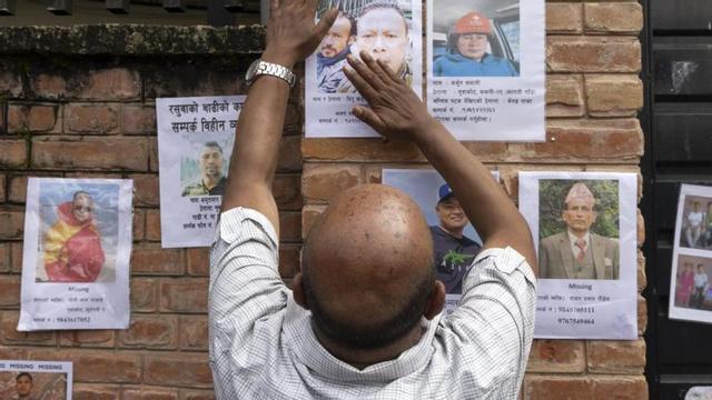 Un nepalès posa fotos fora el dipòsit de cadàvers per identificar els morts. | NARENDRA SHRESTHA / EFE