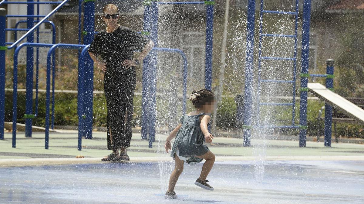 Una niña juega en una fuente en Ourense. |   // ROSA VEIGA