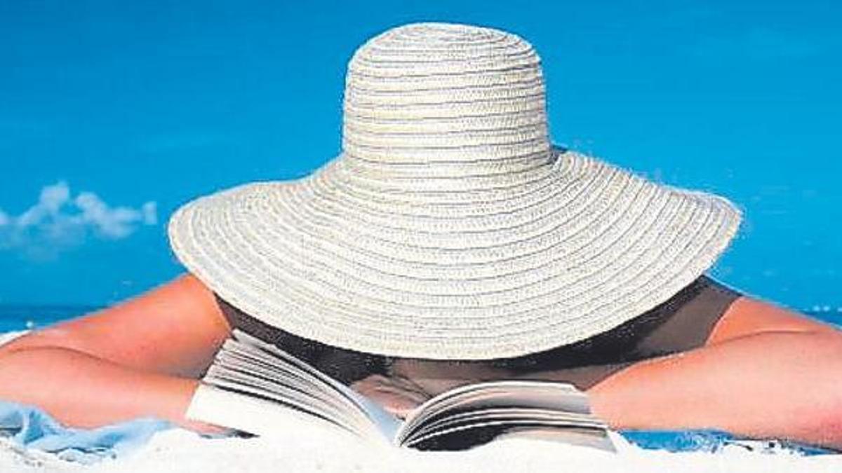Una dona, llegint en una platja.
