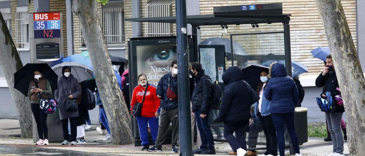 Usuarios del autobús urbano esperando en la parada de autobús en San Juan de la Peña, coincidiendo con los paros de 14.00 a 15.00 horas.    | JAIME GALINDO