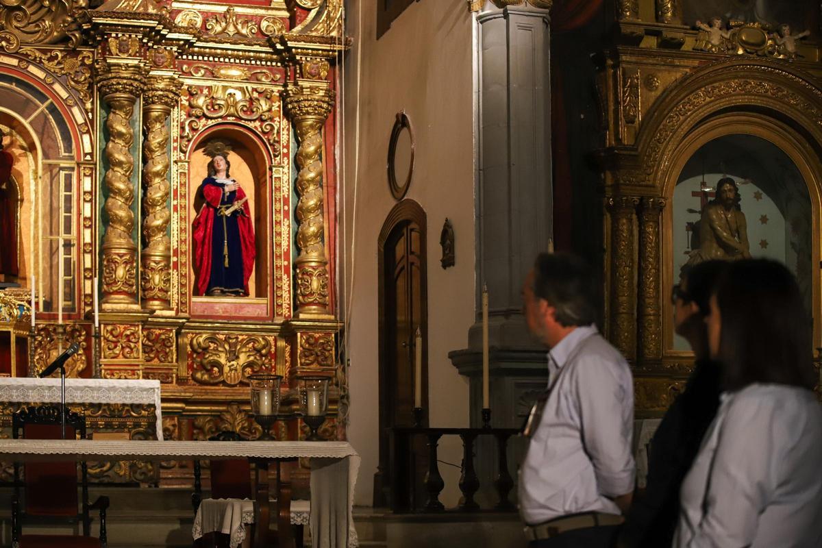 Unos visitantes observan el retablo central.