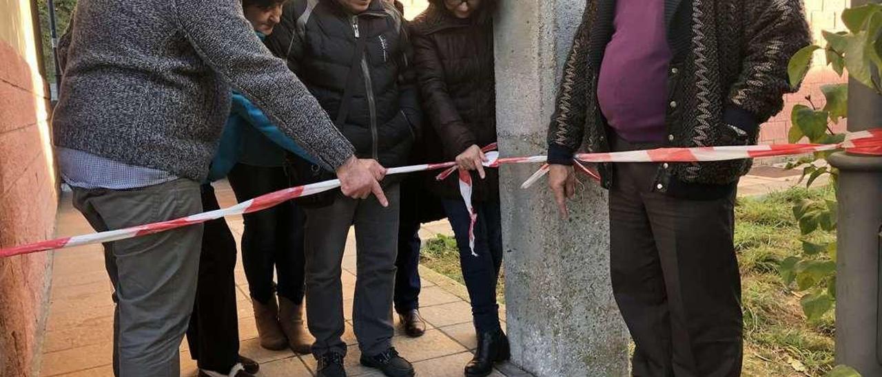 A la izquierda, Francisco Vega, Josefa Ibias, Ángeles Bueno (detrás), José Luis García, Edelmira Álvarez (detrás), Paula Gómez y Jesús Martínez señalan una de las grietas de la acera.