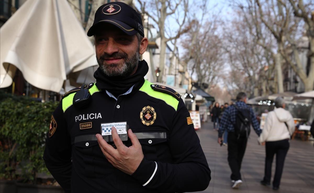 Un agente de la Guardia Urbana de Barcelona prueba la cámara en el uniforme para grabar actuaciones policiales.