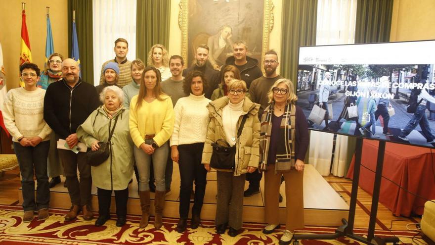 Ángela Pumariega y Sara Menéndez, en el centro, rodeadas de comerciantes y concejales en la presentación del proyecto de rutas comerciales para turistas.