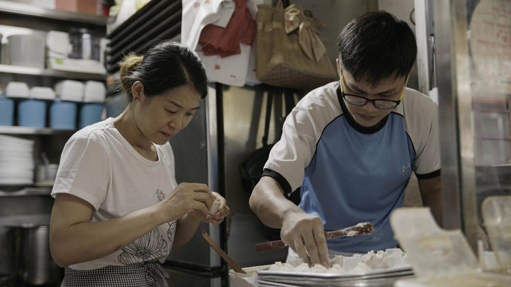 Madre transmitiendo a su hijo la receta de los 'jiaozi'.