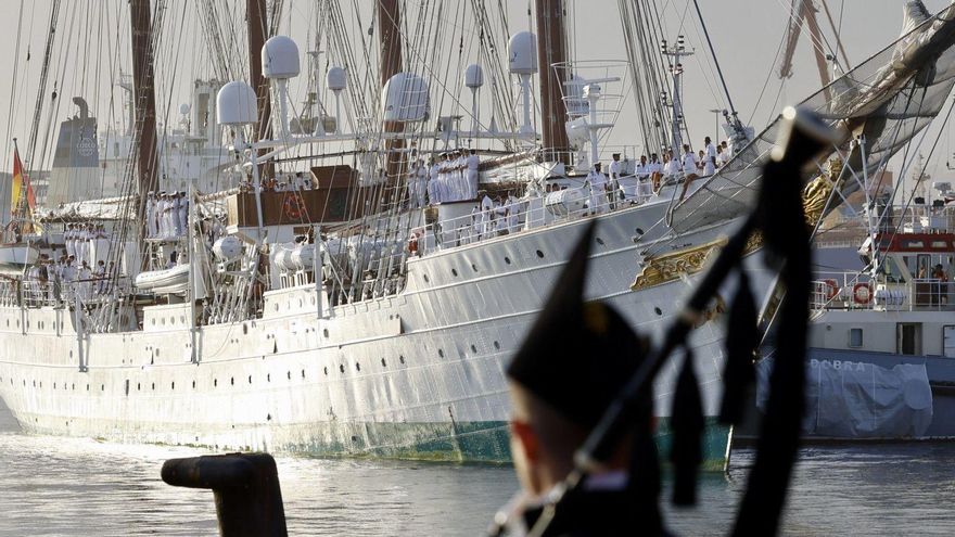 El buque escuela «Juan Sebastián de Elcano», ayer, a su llegada a Gijón, minutos antes de atracar en el espigón II de El Musel. En primer término, de espaldas, un gaitero de la banda «Saxum». | MARCOS LEÓN
