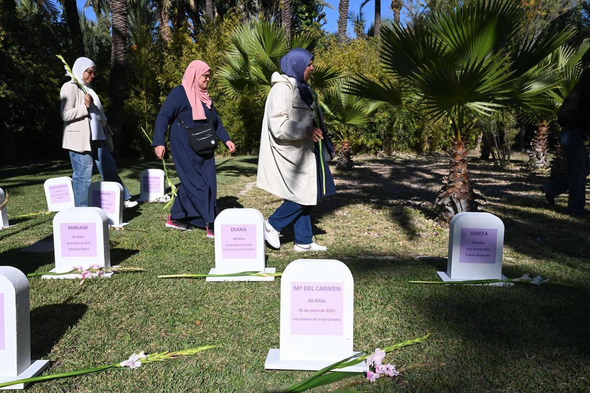 Tres mujeres árabes colocan flores en las tumbas