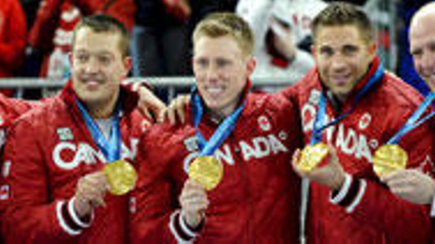 El equipo canadiense de curling posan con las medallas de oro.