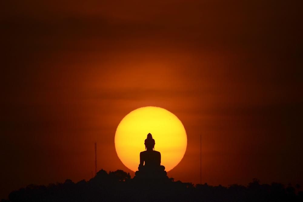 Puesta de sol tras una estatua de Buda en Phuket, Tailandia.