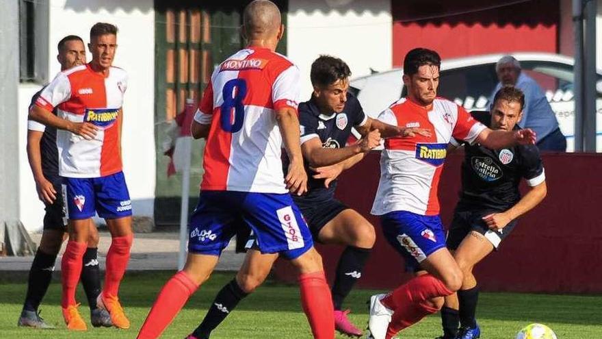 Un jugador del Arosa intenta escapar de un rival, durante la primera jornada de liga. // Abella