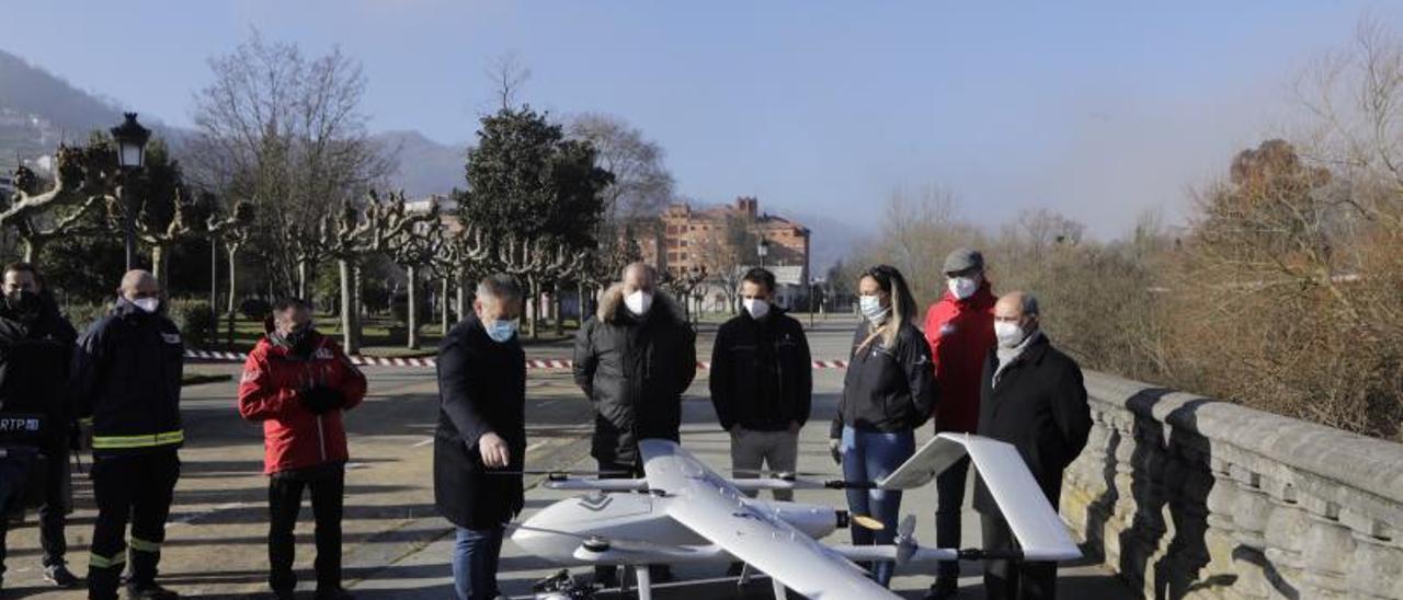 La consejera de Presidencia observa el dron de ala fija con despegue vertical junto a otros asistentes al acto.