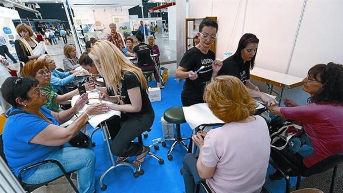 Acicalándose las uñas 8 Alumnas de la escuela Cazcarra, ayer, hacen la manicura a visitantes de la feria.