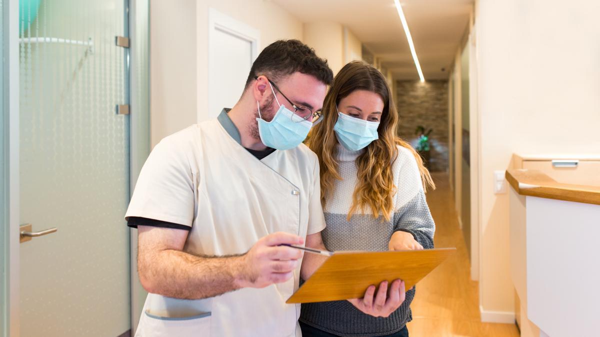 Enfermera explicando notas a una paciente en un centro de salud