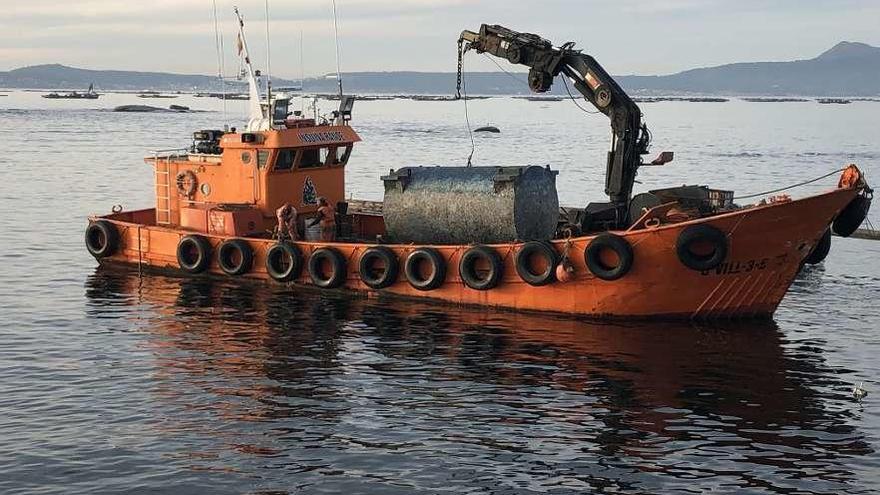 El barco &quot;Insuiña Rande&quot; traslada un bidón de bateas que se había hundido, en O Grove. // Muñiz