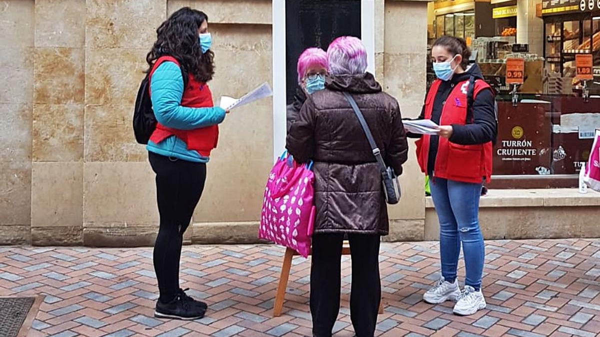 Voluntarias de Cruz Roja haciendo campaña de sensibilización contra la violencia de género, ayer.| J. A. G.