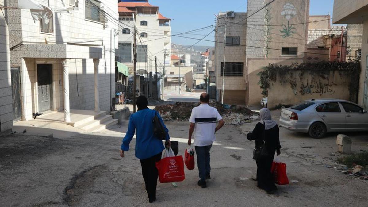 Varios vecinos de Huwara caminan hacia la calle principal, declarada zona militar cerrada por el Ejército israelí.