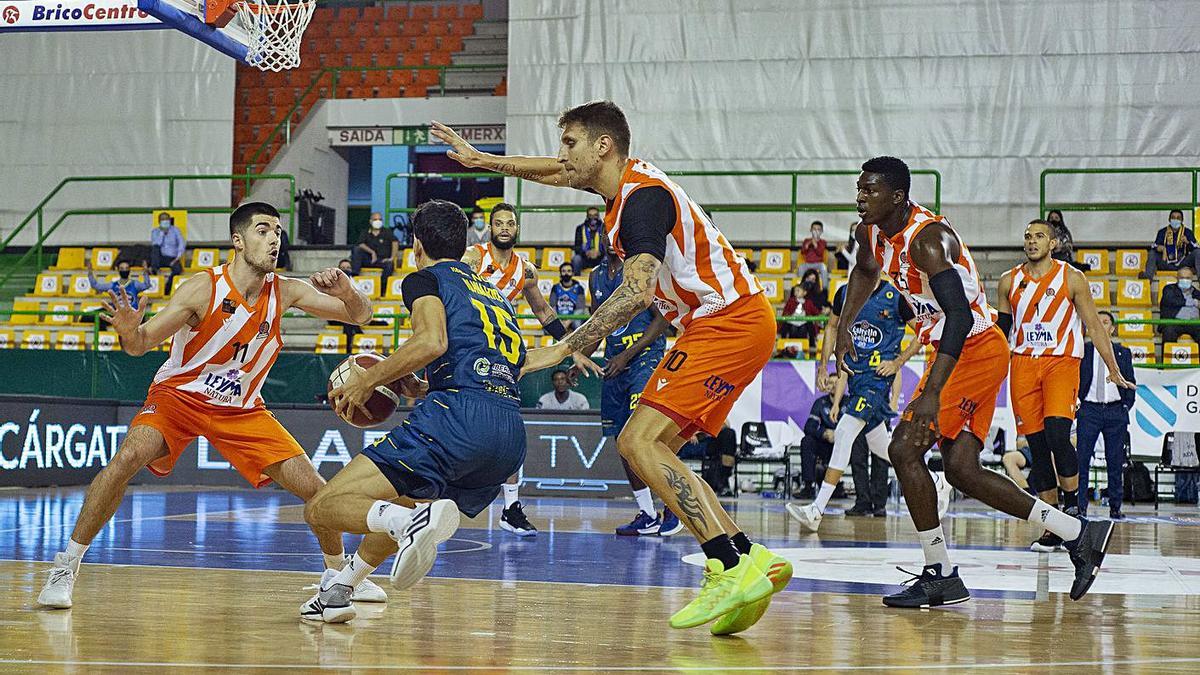 David Navarro busca el aro del Coruña rodeado de jugadores herculinos, ayer en el Paco Paz. |  // CARLOS P.