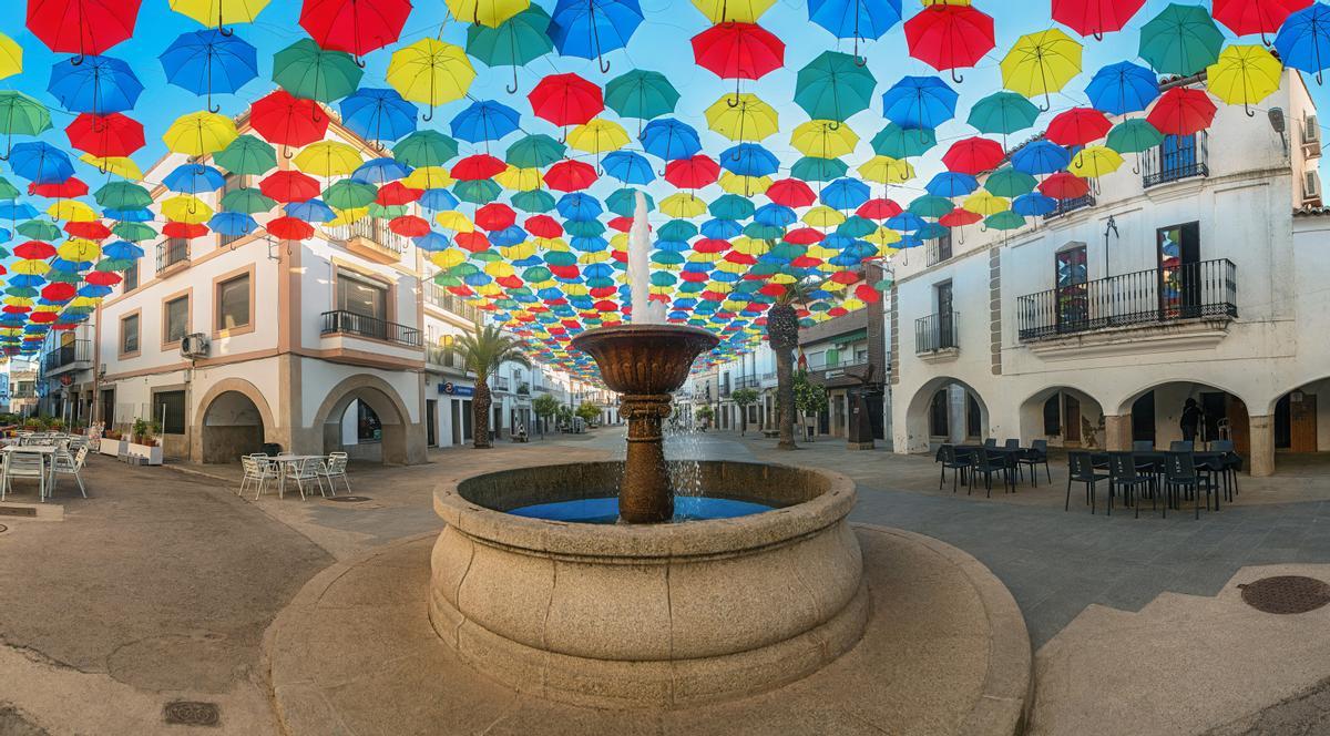 Miles de paraguas dan sombra en la plaza Mayor de Malpartida de Cáceres.