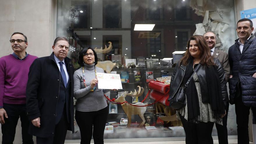 De izquierda a derecha, Enrique Maradona, Canteli, Inmaculada Fernández, Davinia Suárez, Severino Zaragoza y Javier Cuesta posan ante el escaparate de la librería del Rosal que logró el primer premio. | Luisma Murias