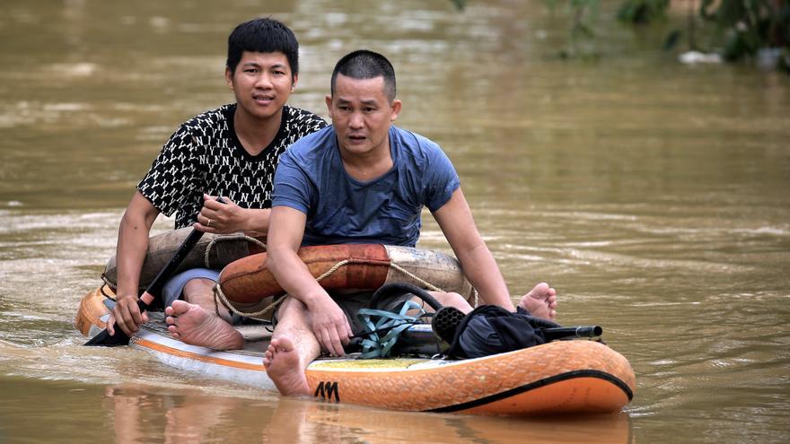 Dos hombres se desplazan en un bote en medio de la inundación en una calle de Hanoi, el martes.