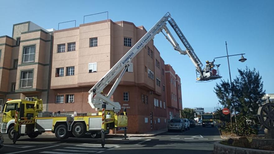 Los bomberos durante la retirada de la iluminaria de la farola en Playa de Arinaga.