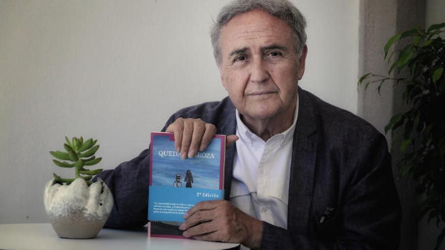 Vicente Molina Foix sosteniendo en sus manos el libro Queda la broza.
