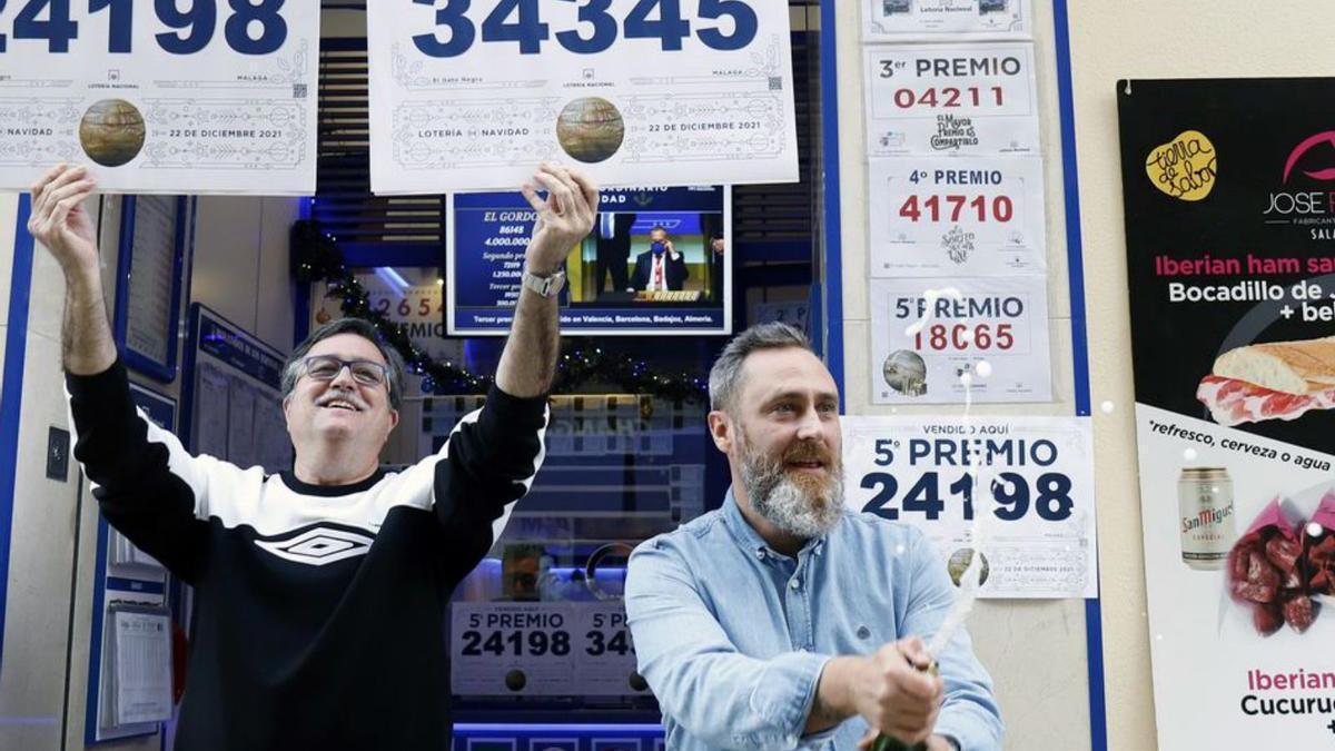 El propietario de la administración El Gato Negro, Miguel Ángel Jiménez, junto a su trabajador Miguel Ponce, celebran los dos quinto premios que ha tocado en dicha lotería que han sido 120.000€.