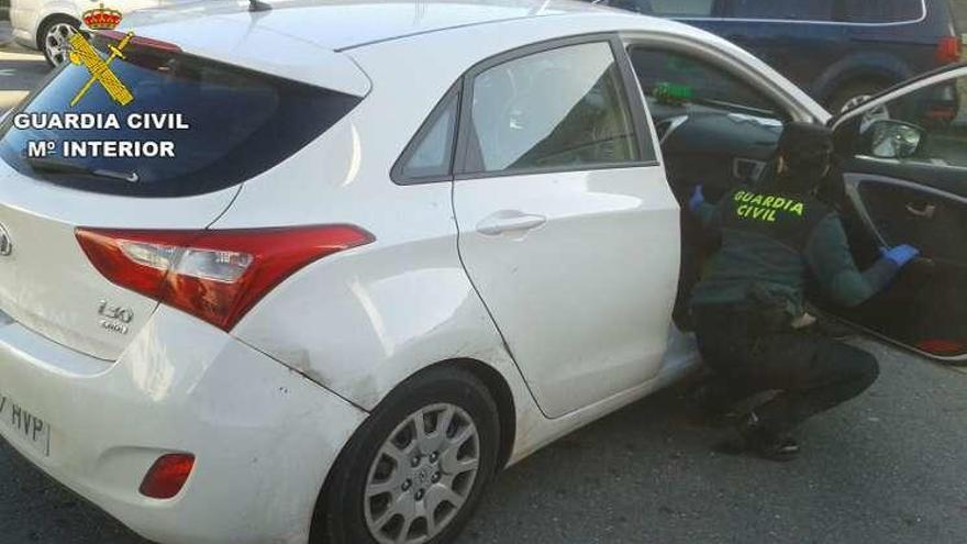 Un agente examina el vehículo robado en Portugal y utilizado en la fuga. // FdV