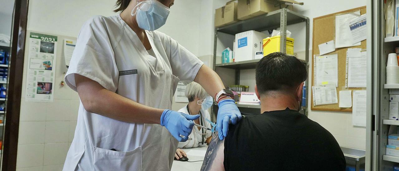 Valencianos incluidos en el grupo de riesgo recibiendo su tercera dosis de vacuna anticovid ayer en el centro de salud de Paterna. | JOSÉ MANUEL LÓPEZ