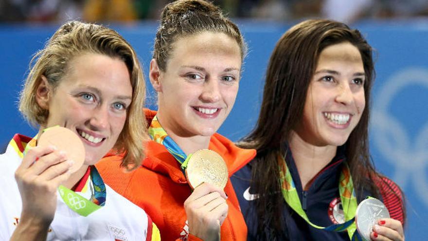 Mireia Belmonte, en primer término, sonríe con su medalla de bronce junto a Hosszu, oro, y a Maya Dirado, plata.